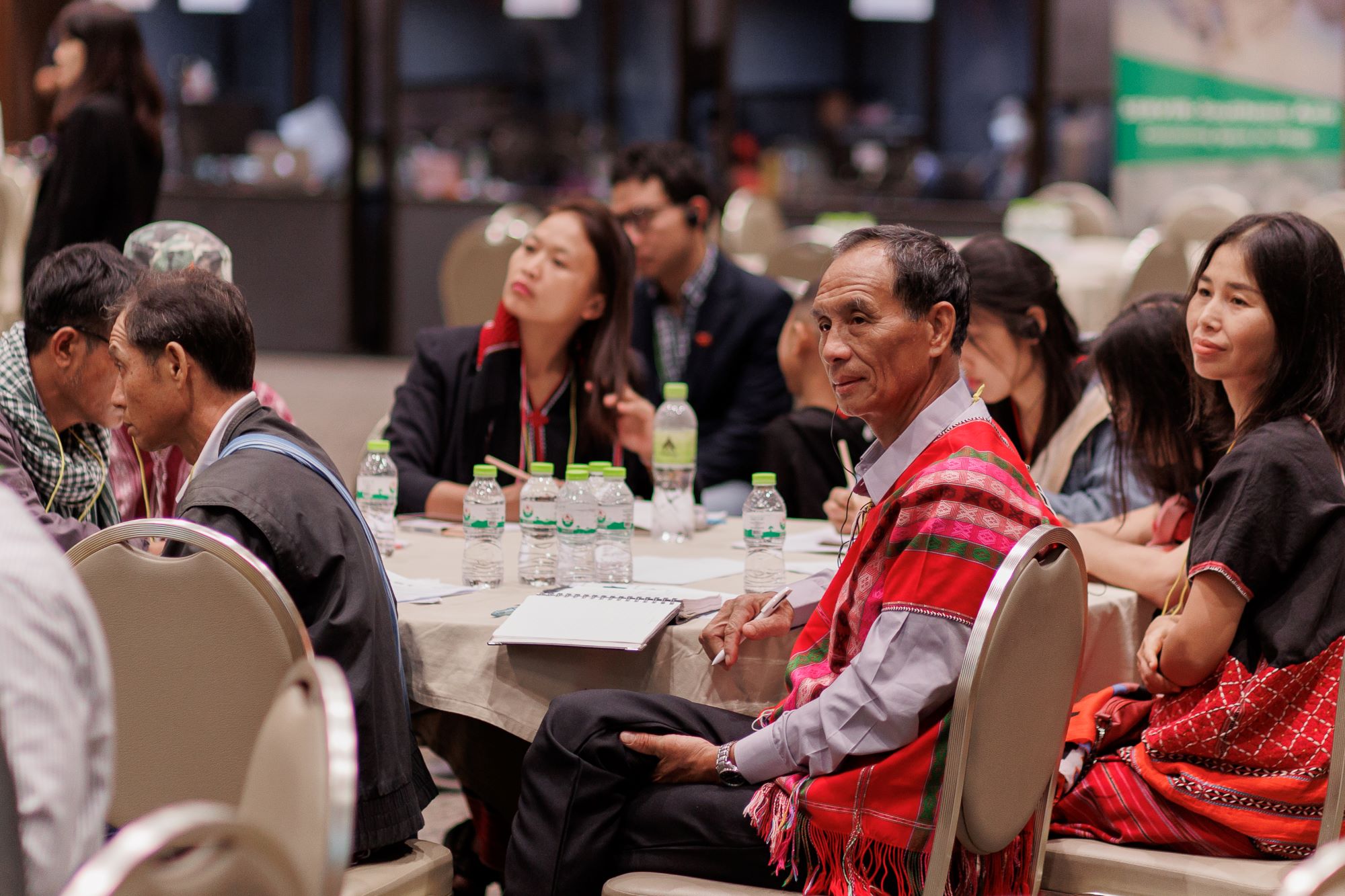 Participants use live translation earpieces to listen to a presentation at the Inclusive Climate Action Workshop. Credit: ADPC