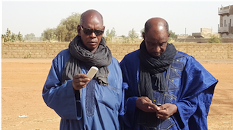 Two pastoralists receive information by cell phone