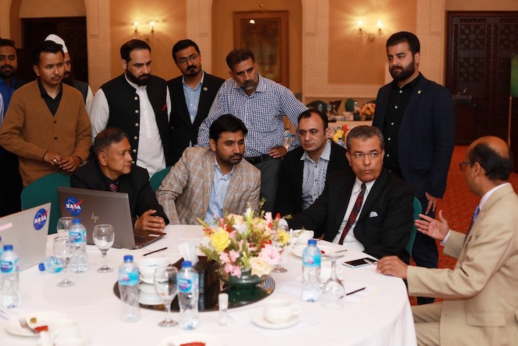 Photo of ICIMOD officials and Inspector General Jaudat Ayyaz seated around a table, with others standing, at the workshop