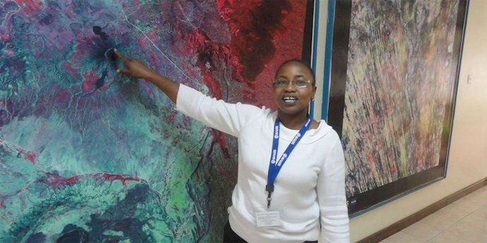Photo of RCMRD's Anastasia Wahome pointing at map