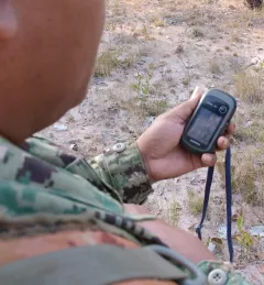 A forest ranger looks at a GPS device in the Prey Lang Forest, Cambodia. Source: https://usaidgreeningpreylang.exposure.co/meet-saminbsp